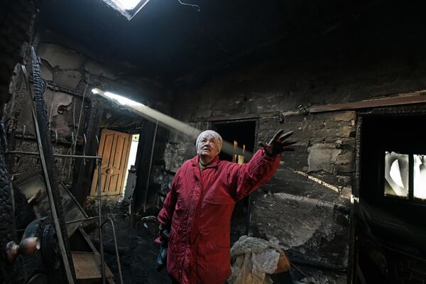 《我们只需等待》，二等奖，俄罗斯 泰西娅·沃龙佐娃。 在顿涅茨克附近的一个村庄叶列诺夫卡，一位老妇人站在邻居被烧毁的房子里。 一枚乌克兰射弹直接击中屋顶，房屋立即起火，房主幸存。 - 俄罗斯卫星通讯社
