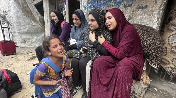 Выжившие палестинцы перед обломками дома своей семьи после авиаудара Израиля по лагерю беженцев Нусейрат в секторе Газа - 俄羅斯衛星通訊社