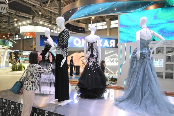 “俄羅斯”國際展覽暨論壇 女參觀者正在展覽開幕式上仔細看連衣裙。 - 俄羅斯衛星通訊社