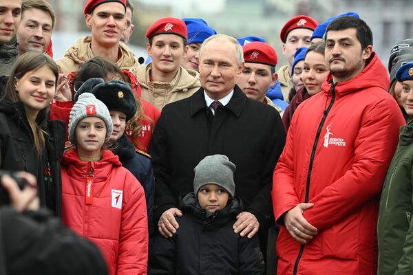2023年11月4日。俄罗斯总统弗拉基米尔·普京在俄罗斯人民团结日向红场库兹马·米宁和德米特里·波扎尔斯基纪念碑献花后，与志愿者、侦察行动成员和牺牲的特别军事行动英雄的子女合影。 - 俄罗斯卫星通讯社