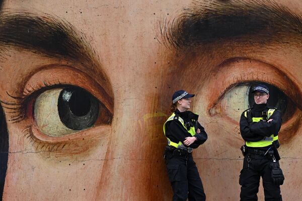 在伦敦市中心特拉法加广场举行的 &quot;伦敦支持巴勒斯坦集会 &quot;之前，警察在意大利艺术家安托内罗•达•梅西那的《男人肖像》复制画前。 - 俄罗斯卫星通讯社