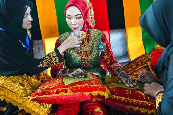 印度尼西亚，在班达亚齐举行的亚齐文化周比赛中，模特们在手绘该地区新娘在传统婚礼上的会绘制的凤仙花图案。 - 俄罗斯卫星通讯社
