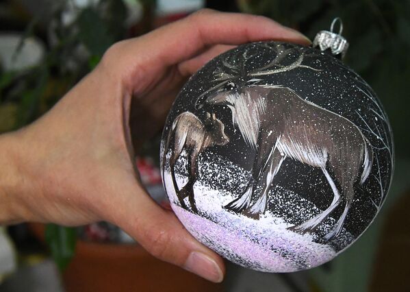 在克拉斯诺亚尔斯克的“比留辛卡”玩具厂，一名艺术家将手绘完成的玻璃新年饰品放在桌子上。 - 俄罗斯卫星通讯社