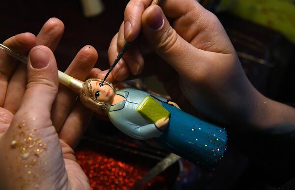 在克拉斯诺亚尔斯克的“比留辛卡”玩具厂，一名艺术家根据市“教师和导师年”绘画比赛获奖者、第149学校三年级学生玛格丽塔·雅科夫列娃的绘画，手绘了一个教师造型的模制玻璃新年装饰。 - 俄罗斯卫星通讯社