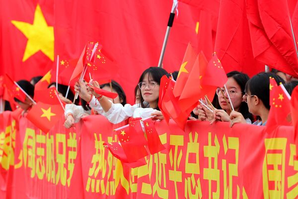 习近平和夫人彭丽媛抵达河内内排国际机场前，民众挥舞着中越两国国旗 - 俄罗斯卫星通讯社