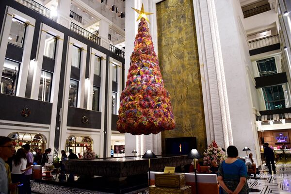 2023年12月10日，圣诞节前夕，在艾哈迈达巴德的ITC纳尔默达酒店，客人们走过一棵由大约300把伞组成的圣诞树，这些伞来自印度古吉拉特邦的库奇地区。 - 俄罗斯卫星通讯社