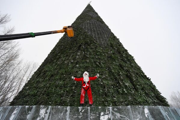 在克拉斯诺亚尔斯克塔蒂谢夫岛安装 57 米城市主圣诞树的光动力照明系统元件时，身着圣诞老人服装的俄供热系统设备制造供应商”Sibpromenergomash”公司的安德烈·尼古拉耶夫。 - 俄罗斯卫星通讯社