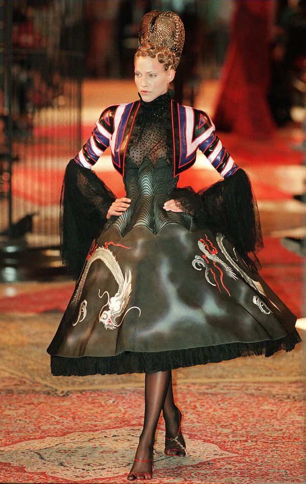 英國設計師亞歷山大·麥昆在巴黎展示了一件中國龍裝飾的寬流蘇連衣裙，黑紅相間，袖口飾有蕾絲花邊和幾何圖案，是紀梵希1997/98秋冬高級時裝系列的一部分。 - 俄羅斯衛星通訊社