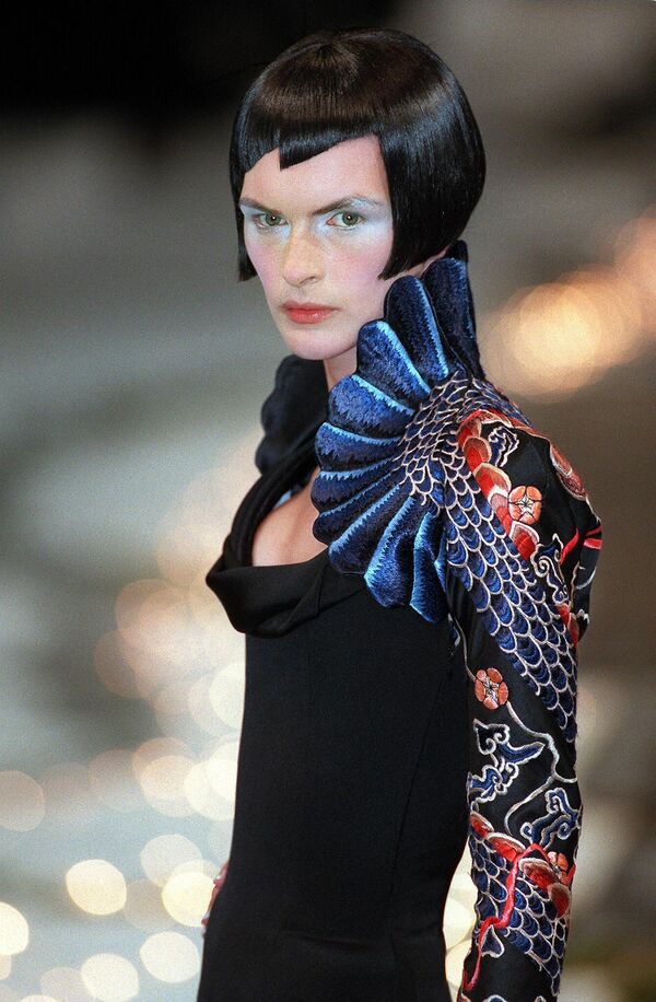 在巴黎舉行的1998年春夏高級時裝發佈會上，模特展示由英國造型師亞歷山大·麥昆為紀梵希設計的龍形長袖扇形領低胸黑色連衣裙。 - 俄羅斯衛星通訊社