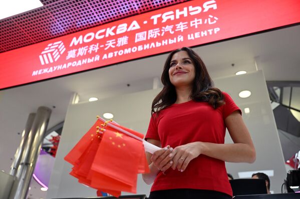 汽車中心內手持中國國旗的服務人員。 - 俄羅斯衛星通訊社