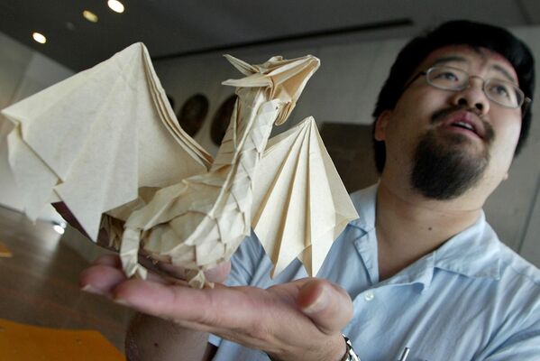 2004年8月20日，東京摺紙大會上，加拿大專業摺紙藝術家約瑟夫-吳手持他最喜歡的摺紙藝術品“龍”接受美聯社的採訪。 - 俄羅斯衛星通訊社