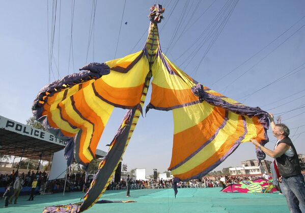 2008年1月12日，在印度艾哈迈达巴德举行的国际风筝节上，德国选手（右）在放飞16米长（52英尺）的龙形风筝。 - 俄罗斯卫星通讯社