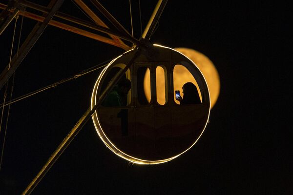伊拉克巴士拉市摩天輪座艙後升起的一輪“寒月”。 - 俄羅斯衛星通訊社