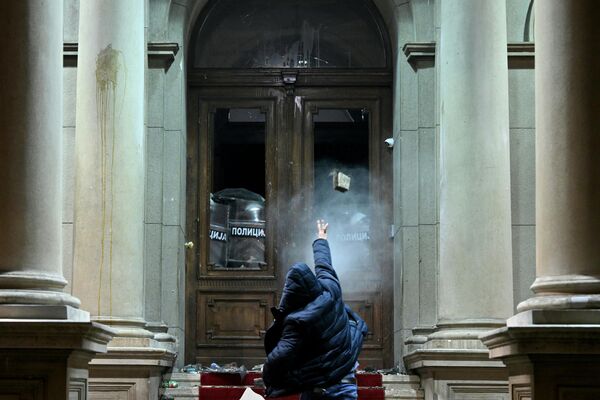 一名抗議者向塞爾維亞貝爾格萊德市議會大樓內使用胡椒噴霧的警察投擲彈丸。 - 俄羅斯衛星通訊社