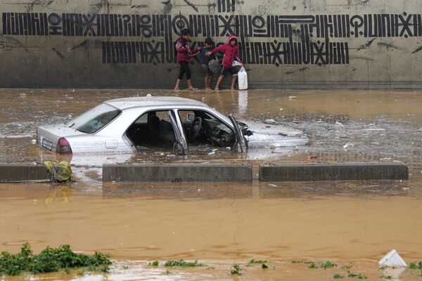 黎巴嫩贝鲁特，男孩们雨后在被洪水淹没的汽车前走过。 - 俄罗斯卫星通讯社