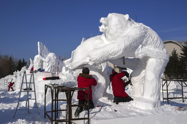 2024年1月8日，工人们在中国东北黑龙江省哈尔滨市一年一度的哈尔滨冰雪大世界雕刻雪雕。(Caroline Chen/美联社） - 俄罗斯卫星通讯社