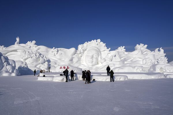 2024年1月8日，中国黑龙江省哈尔滨市，游客们在哈尔滨冰雪大世界观看一座巨型雪雕。(Caroline Chen/美联社） - 俄罗斯卫星通讯社