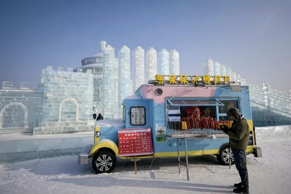 2024年1月5日，一位女子站在哈尔滨冰雪大天下的餐车旁。(Pedro PARDO /法新社） - 俄罗斯卫星通讯社