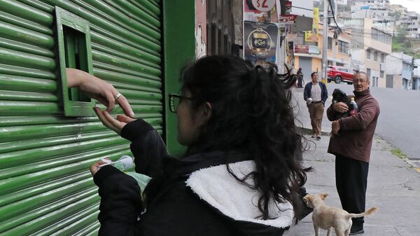Девушка расплачивается за продукты через окошко в Кито  - 俄罗斯卫星通讯社