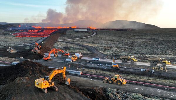 摄于2024年1月14日的鸟瞰图显示，火山爆发后，紧急救援人员使用挖掘机建造防护墙，试图阻止熔岩流到冰岛西南部城镇格林达维克的中心。据冰岛公共广播电台RUV报道，夜间地震活动加剧，格林达维克的居民被疏散。这是冰岛两年来的第五次火山喷发，上一次是在2023年12月18日，在首都雷克雅未克西南的同一地区。冰岛有33个活火山系统，是欧洲最多的。 - 俄罗斯卫星通讯社
