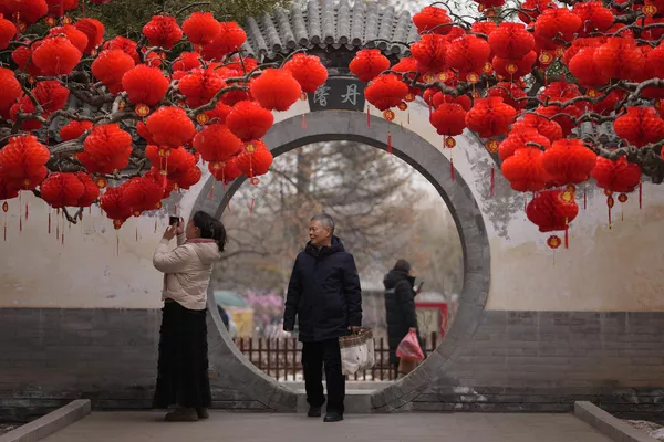 北京地坛公园，市民用智能手机拍摄春节前的红灯笼和装饰品。