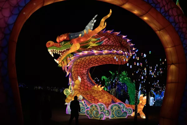 一名男子从北京新年庙会上的龙像前走过。迎接2月10日的农历龙年春节。