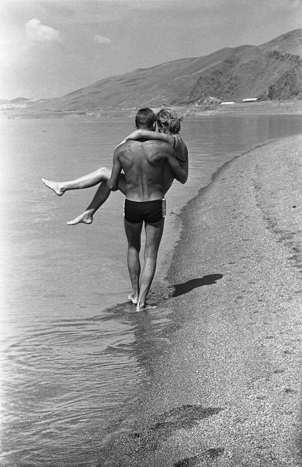 亞美尼亞蘇維埃社會主義共和國埃里溫的 &quot;燕子 &quot;國際青年營。 一對年輕情侶沿著塞凡湖（塞凡湖南岸的營地分部）的沙灘散步。 - 俄羅斯衛星通訊社