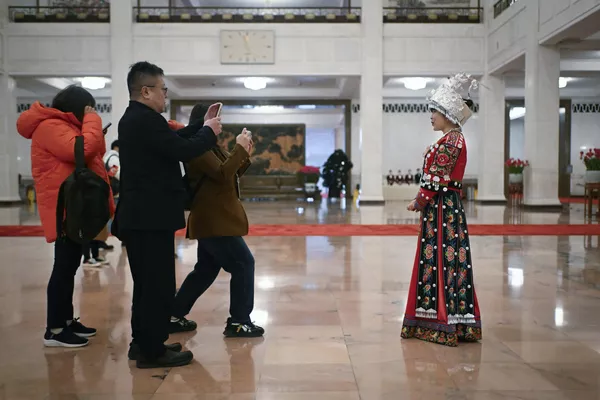 2024年3月4日，少数夷易近族代表(右)在北京国夷易近大礼堂举行的中国十四届天下人大二次团聚开幕式前摄影。 - 俄罗斯卫星通讯社