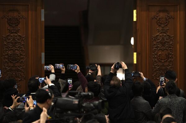 2024年3月4日，星期一，中國十四屆全國人大二次會議開幕前夕，全國人民代表大會發言人婁勤儉在人民大會堂出席新聞發佈會，記者們試圖抓拍。 - 俄羅斯衛星通訊社
