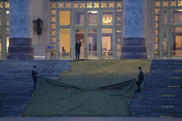3月5日，北京，第十四届全国人大二次会议开幕会开始前，安保人员揭掉人民大会堂台阶上的防雨布。 - 俄罗斯卫星通讯社