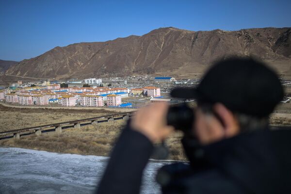 2024年2月26日，一名男子在吉林省图们市用望远镜眺望朝鲜南阳市。 - 俄罗斯卫星通讯社