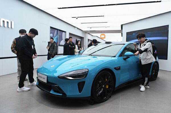 2024年3月26日，人們在北京的小米商店裡參觀小米SU7電動車。 - 俄羅斯衛星通訊社