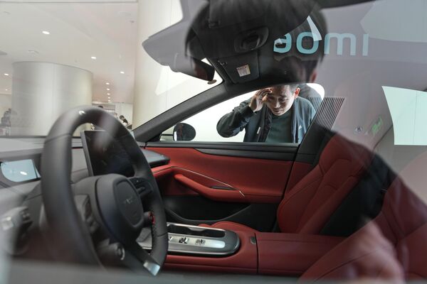 2024年3月26日，星期二，一名男子在北京參觀小米SU7電動汽車的內部。小米，中國知名的智能電子品牌，正在加入中國蓬勃發展但擁擠的電動汽車市場。 - 俄羅斯衛星通訊社