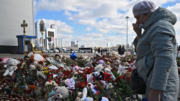 Женщина плачет у стихийного мемориала в память о жертвах теракта в Крокус Сити Холле - 俄罗斯卫星通讯社