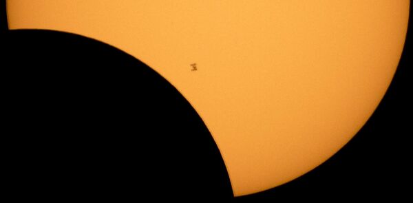 2017年8月21日，从华盛顿州北喀斯喀特国家公园罗斯湖看到的日偏食期间，国际空间站在太阳的映衬下呈现出轮廓。 - 俄罗斯卫星通讯社