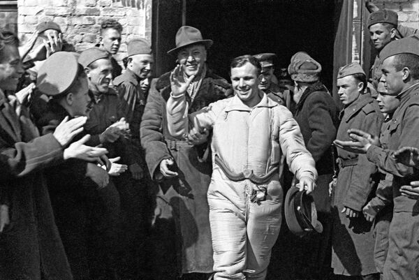 世界第一位宇航員尤里·加加林在“東方1號”飛船降落艙著陸後向人群招手，圍在其周圍的是由導彈師師長加西耶夫少校和當地居民組成的搜索隊。 - 俄羅斯衛星通訊社