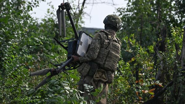 Военнослужащий подразделения противовоздушной обороны группировки Центр несет сбитый БПЛА Баба Яга на боевых позициях на Авдеевском направлении СВО - 俄罗斯卫星通讯社