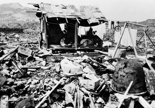 1945年9月14日，長崎，一戶日本家庭在故居的廢墟上，用殘骸搭起簡陋的棚屋，在裡面吃飯。 - 俄羅斯衛星通訊社