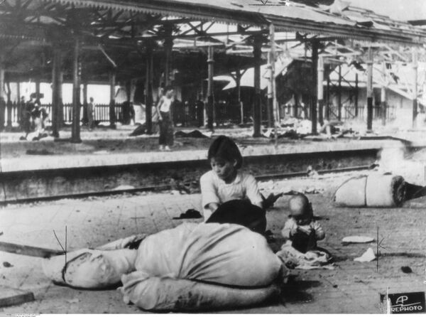 抗日战争早期（1937年9月至10月），一名妇女和一名婴儿站在中国某城市（可能是上海）被炸毁的火车站站台上的照片。 - 俄罗斯卫星通讯社