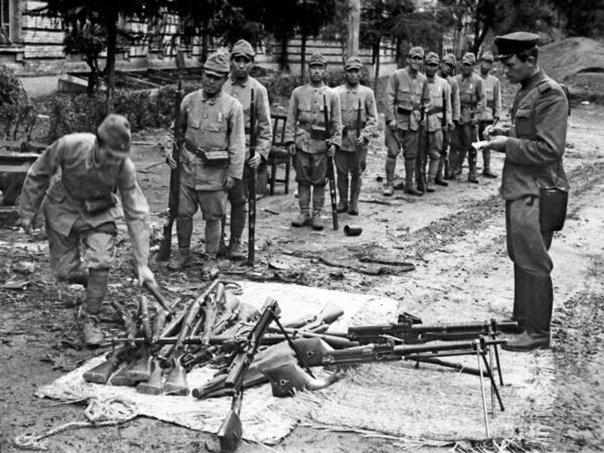 投降的日本关东军士兵向苏军军官缴械。地上堆放着“九九式”阿里萨卡步枪和“十一式”南部机枪。  - 俄罗斯卫星通讯社, 1920, 03.09.2025