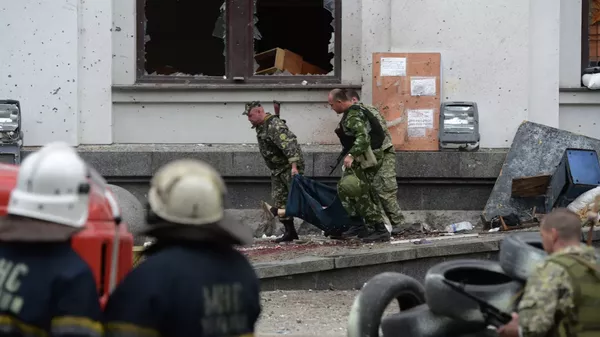 卢甘斯克地区行政大楼遭乌克兰空军空袭，民兵抬着一名遇难者。 - 俄罗斯卫星通讯社