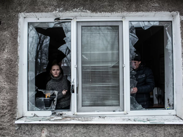 在乌克兰顿涅茨克中部沃罗希洛夫斯基区，一名女子透过被乌克兰炮火击中后破碎的公寓窗户向外张望。 - 俄罗斯卫星通讯社