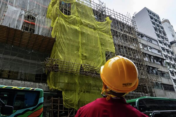一名建築工人站在旺角地區一幢正在翻新的建築附近 - 俄羅斯衛星通訊社