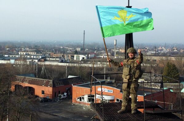 一名隸屬於俄軍“北方”集團軍的士兵高舉旗幟參與解放蘇賈村。 一名隸屬於俄軍“北方”集團軍的士兵高舉旗幟參與解放蘇賈村。 - 俄羅斯衛星通訊社