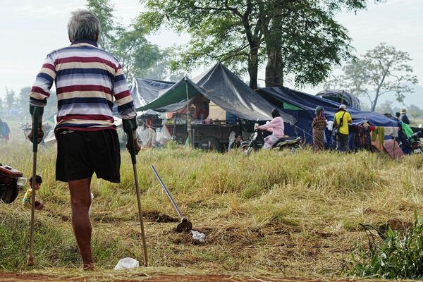 一名疏散者在2025年12月11日泰柬边境再度爆发冲突后逃离家园，在柬埔寨奥多棉吉省钟卡尔稻田避难时望向亲属的临时住所。 - 俄罗斯卫星通讯社