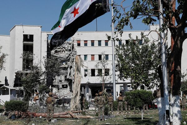 2025年7月19日,敘利亞士兵在首都大馬士革國防部大樓前升起國旗。該大樓此前遭以色列空襲,損毀嚴重。 2025年7月19日,敘利亞士兵在首都大馬士革國防部大樓前升起國旗。該大樓此前遭以色列空襲,損毀嚴重。 - 俄羅斯衛星通訊社