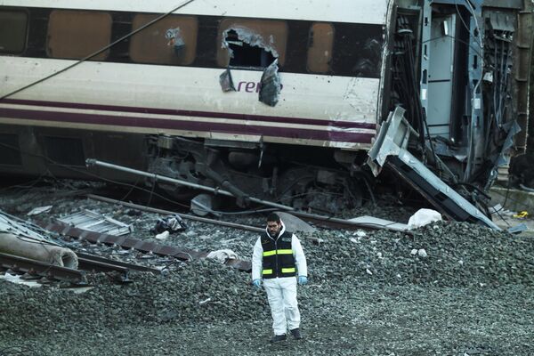2026年1月20日，西班牙科尔多瓦省阿达穆兹附近，一名西班牙宪警站在高速列车致命脱轨事故现场的列车残骸旁。 - 俄罗斯卫星通讯社