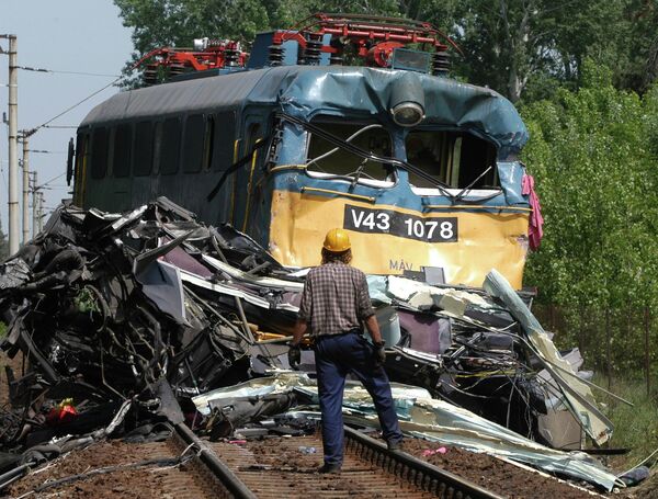 2003年5月8日星期四，匈牙利希欧福克一处铁路道口发生火车与德国大巴相撞事故。图为一名匈牙利男子正在查看事故后火车机车的受损情况。事发地点位于布达佩斯以西110公里处的巴拉顿湖附近。 - 俄罗斯卫星通讯社