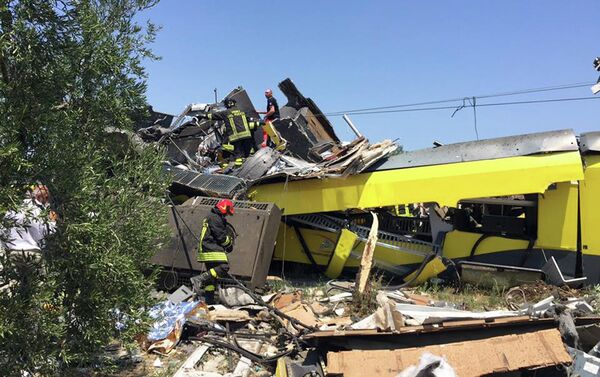 2016年7月12日周二，意大利南部普利亚大区安德里亚镇附近发生两列通勤列车迎面相撞事故，造成多人死亡。图为消防人员正在事故现场的废墟中进行搜救。 - 俄罗斯卫星通讯社