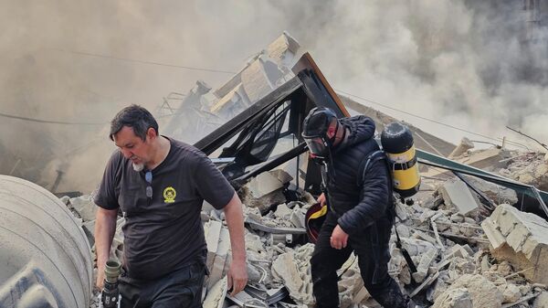 在贝鲁特南部郊区达希耶，以色列空袭后，消防员正在检查冒着浓烟的废墟。 - 俄罗斯卫星通讯社